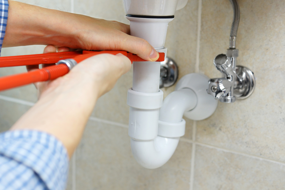 man fixing plumbing to prevent flood